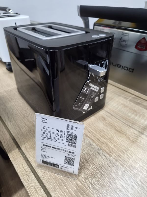 Чёрный тостер Tefal на витрине магазина электроники, на подставке два ценника: обычный и «Yarim narxini to'lang» (рассрочка)