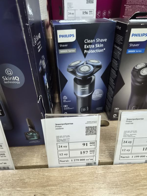 Электробритва Philips Shaver 5000X Series X5006/00 в коробке с белым ценником на полке магазина электроники