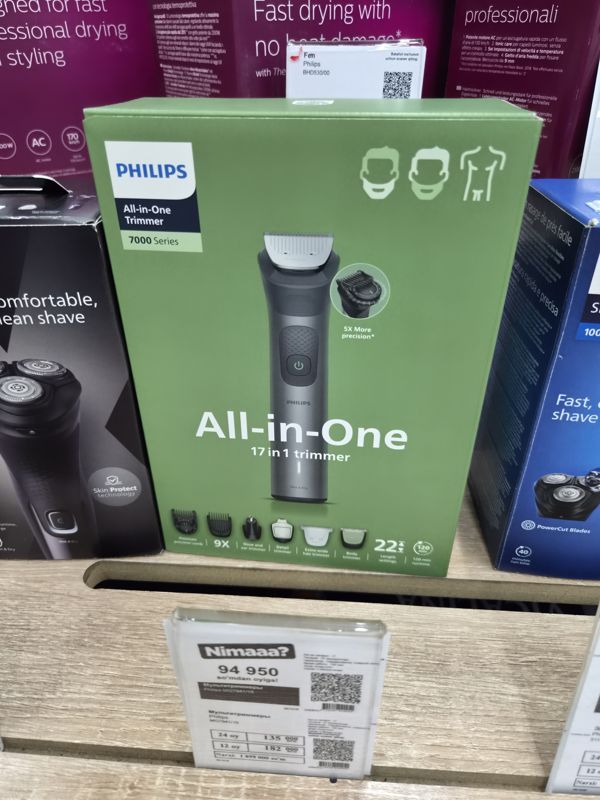 Мультитриммер Philips All-in-One Trimmer 7000 Series в зелёной коробке на полке магазина электроники, под ней белый ценник магазина