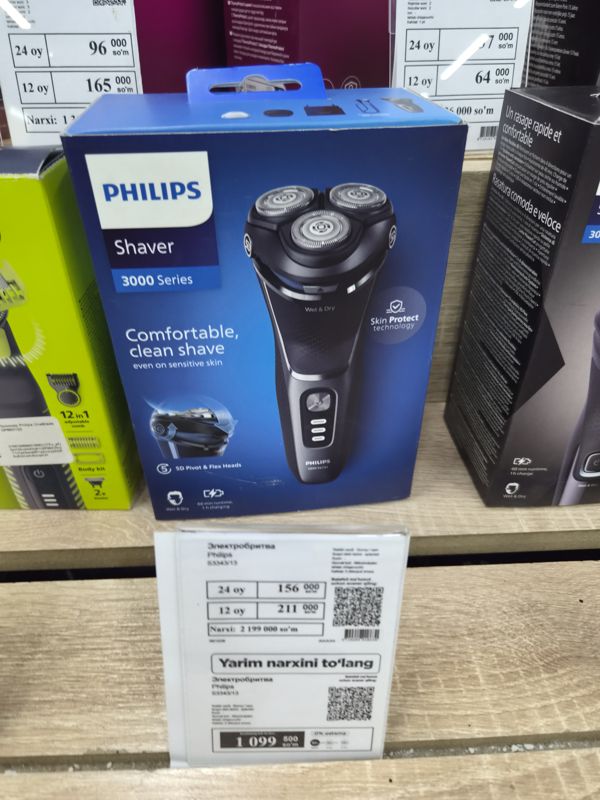 Электробритва Philips Shaver 3000 Series в коробке на полке с белым ценником магазина электроники