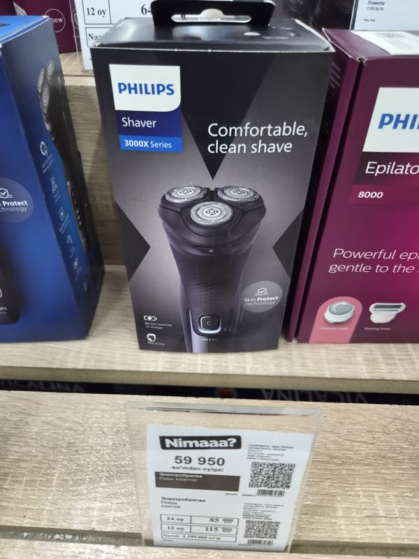 Электробритва Philips Shaver 3000X Series в коробке на полке магазина электроники, под ней ценник с моделью X3001/00