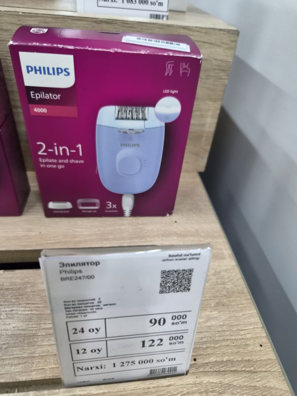 Эпилятор Philips BRE247/00 в коробке Epilator 4000 2-in-1 и белый ценник магазина электроники на светлой полке