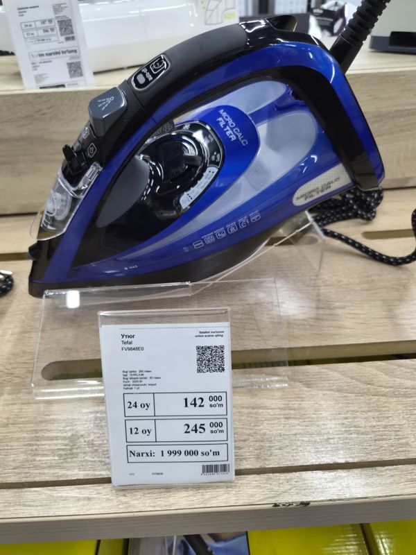 Утюг Tefal FV9848E0 с синим корпусом на акриловой подставке с белым ценником на полке магазина электроники