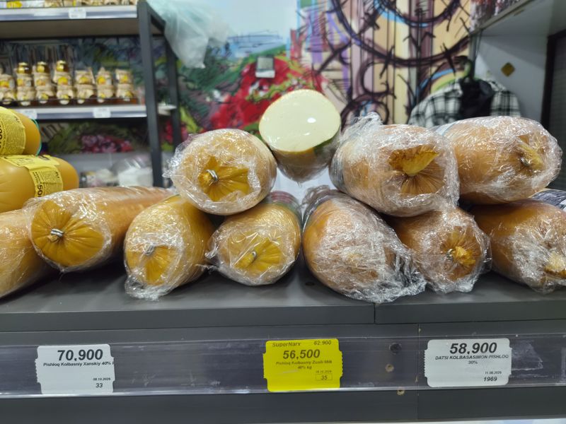 Полка с колбасными сырами Ханский, Zually Milk и Datsi в плёнке; ценники Сырной лавки