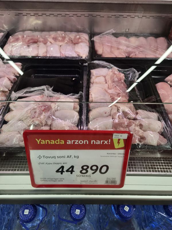 Витрина с охлаждённым куриным бедром на лотках и красным ценником «Yanada arzon narx!» 44 890 сум/кг