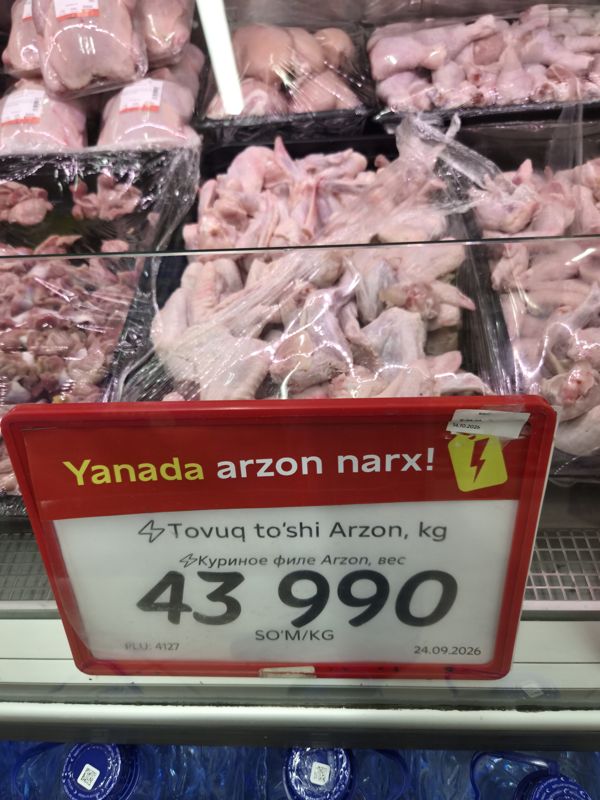 Витрина с куриными крыльями и тушками и красным ценником «Yanada arzon narx!» на куриное филе Arzon 43 990 сум/кг