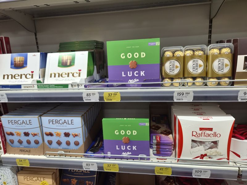 Полки с подарочными конфетами и шоколадом в Korzinka: Merci, Milka Good Luck, Ferrero Rocher, Pergale, Raffaello, Milka Oreo, Победа