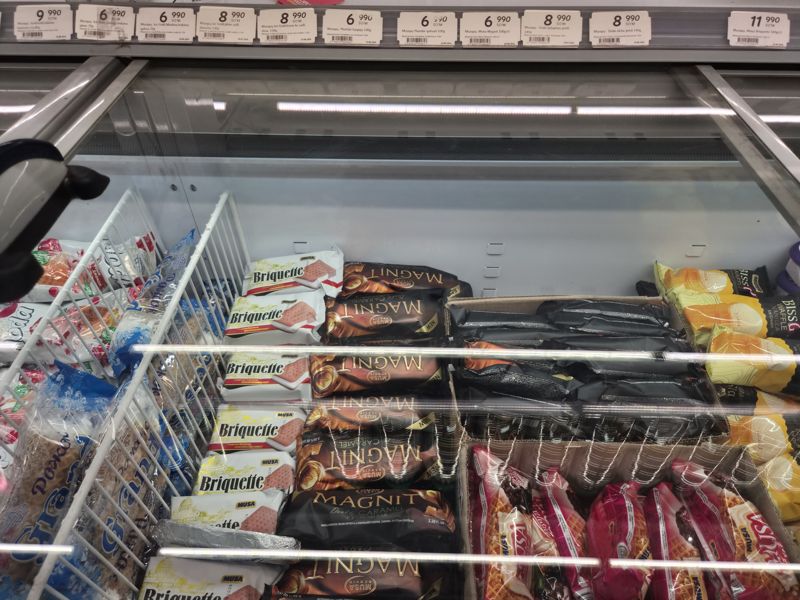 Морозильный ларь с мороженым в Korzinka: Musa Briquette и Magnit, Ice Gold, Doda, пломбир; ряд ценников над витриной