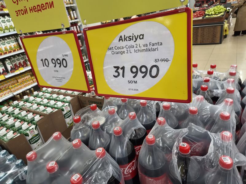 Островная выкладка в Korzinka: сок «Сочная долина» яблочный 1 л и Coca-Cola 2 л в плёнке под жёлтыми акционными ценниками