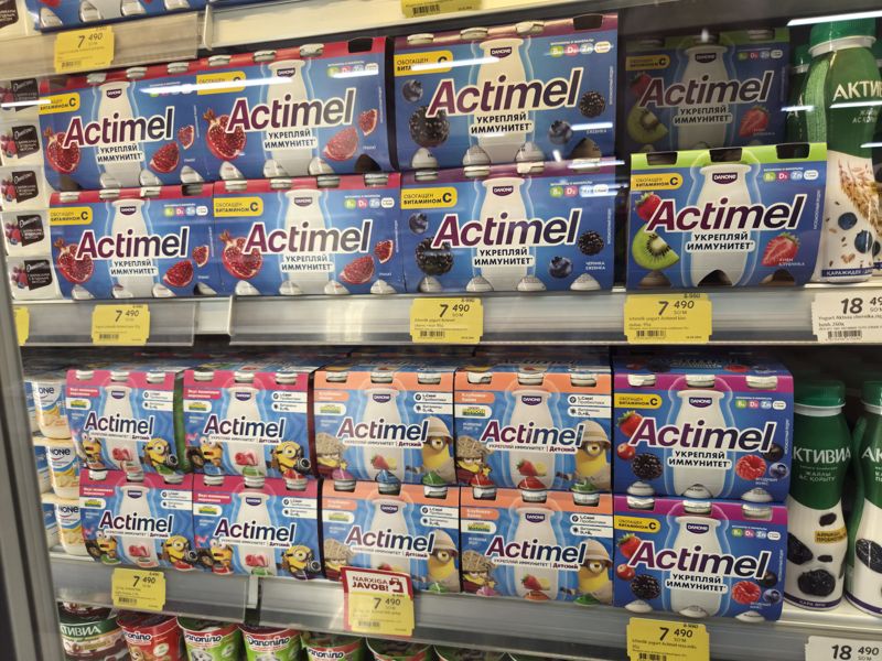 Холодильная полка с питьевыми йогуртами Actimel: жёлтые акционные ценники 7 490 сум с зачёркнутой старой ценой, один ценник с плашкой «Narxiga javob»