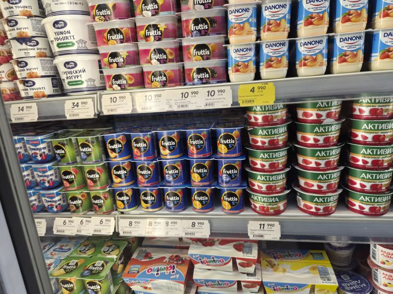 Холодильная витрина с йогуртами Fruttis (8%, 5%, 0,1%), Danone, Активиа, Доброе, Ermigurt и Ikimino; белые ценники и один жёлтый акционный