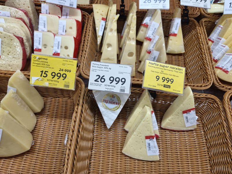 Прилавок сыров на вес в Korzinka: твёрдый Dziugas по скидке, мягкий Brie President и полутвёрдый Germanto Tilsit по акции «Hafta super narxlari», цены за 100 г