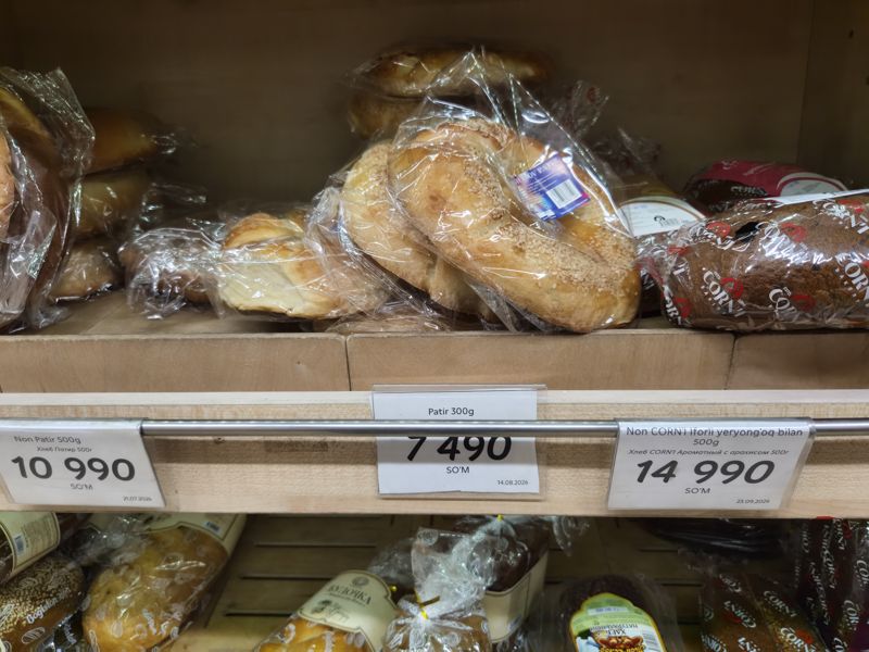 Хлебная полка в Korzinka: патир в пакетах, хлеб CORN'I, три ценника — Non Patir 500 г, Patir 300 г и Non CORN'I с арахисом