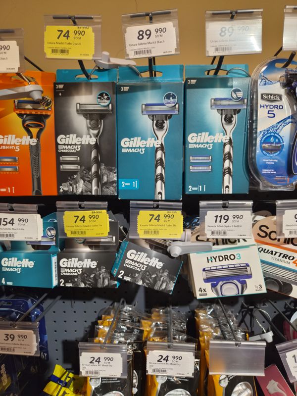 Стеллаж с бритвенными станками и кассетами Gillette Mach3, Schick Hydro, одноразовыми BIC и Gillette Blue3 на крючках с ценниками