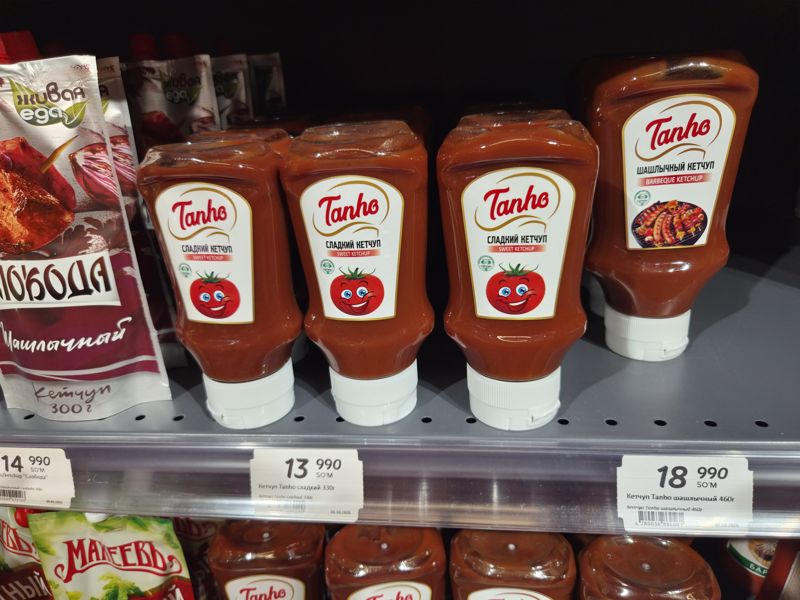 Полка с кетчупом Tanho (сладкий, шашлычный), пакетами Слобода и Живая еда с ценниками