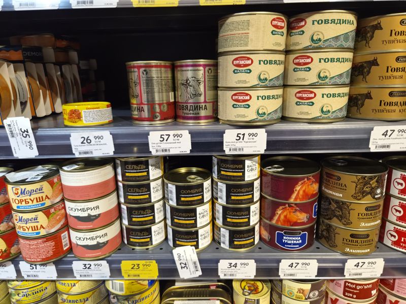 Стеллаж с мясными и рыбными консервами (Курганская, Слонимский, Foodmaxx, Baltic Gold, 5 Морей, Fortuna, Dongwon) с ценниками на полках