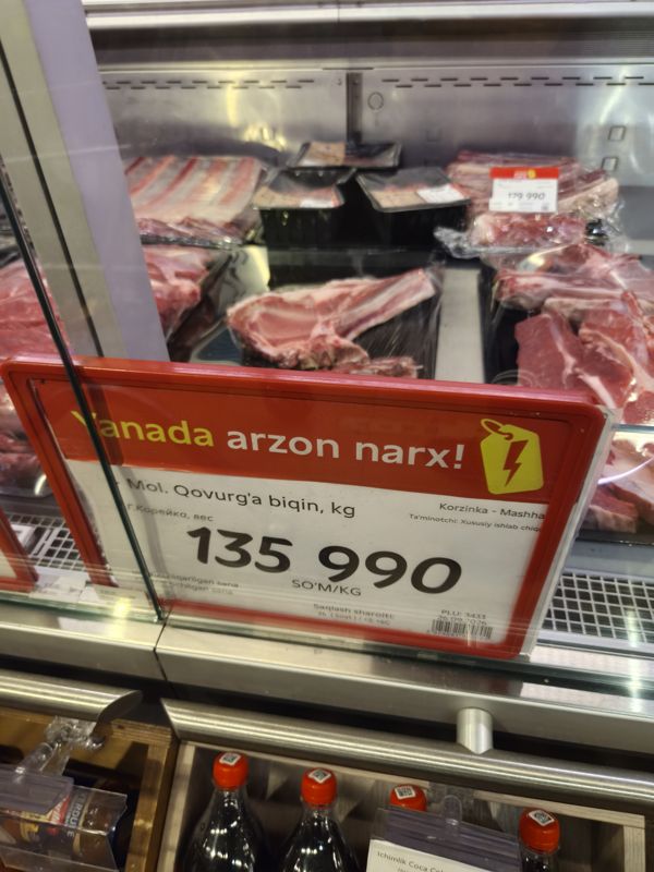 Витрина мяса в Korzinka: красный акционный ценник «Yanada arzon narx!» на говяжью корейку, 135 990 сум/кг
