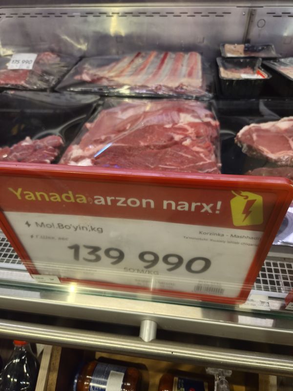 Витрина мяса в Korzinka: красный акционный ценник «Yanada arzon narx!» на говяжью шею, 139 990 сум/кг