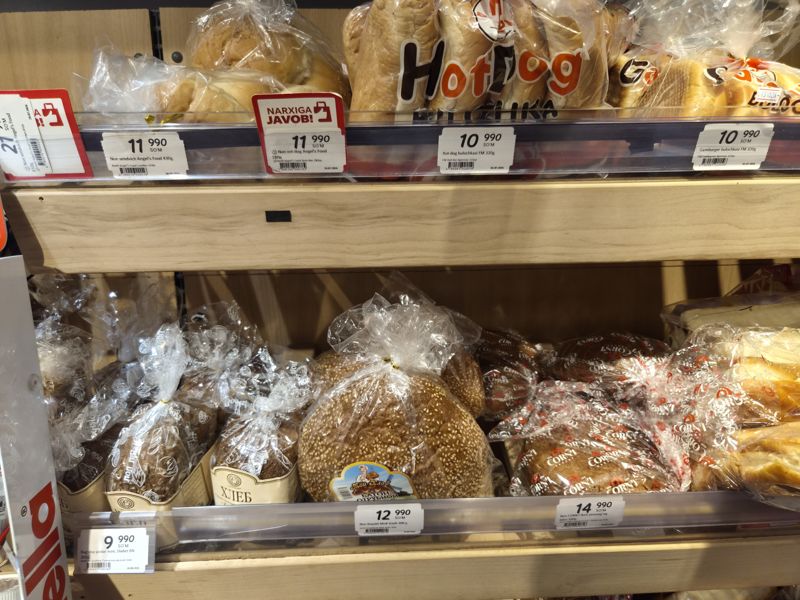 Стеллаж с упакованным хлебом и булочками в Korzinka: ценники Angel's Food, FM, Diabet BN, «Мой Хлеб», CORN'I