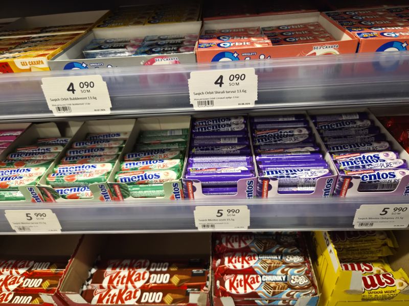 Полки жевательной резинки Orbit и Mentos в Korzinka, под ними KitKat Duo, KitKat Chunky и Nuts; ценники на полках