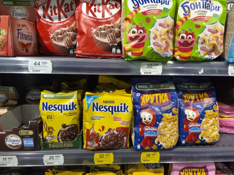 Полки с готовыми завтраками и батончиками Nestle: KitKat, Бон Пари, Nesquik, Хрутка, Fitness; два жёлтых акционных ценника со старой ценой