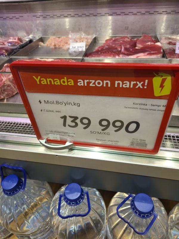 Ценник на говяжью шею с плашкой «Yanada arzon narx» на витрине мяса