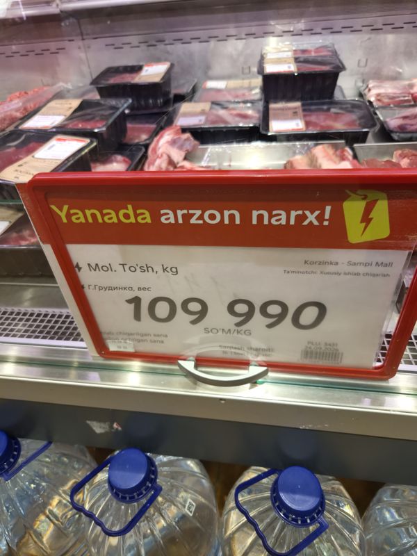Ценник на говяжью грудинку с плашкой «Yanada arzon narx» на витрине мяса