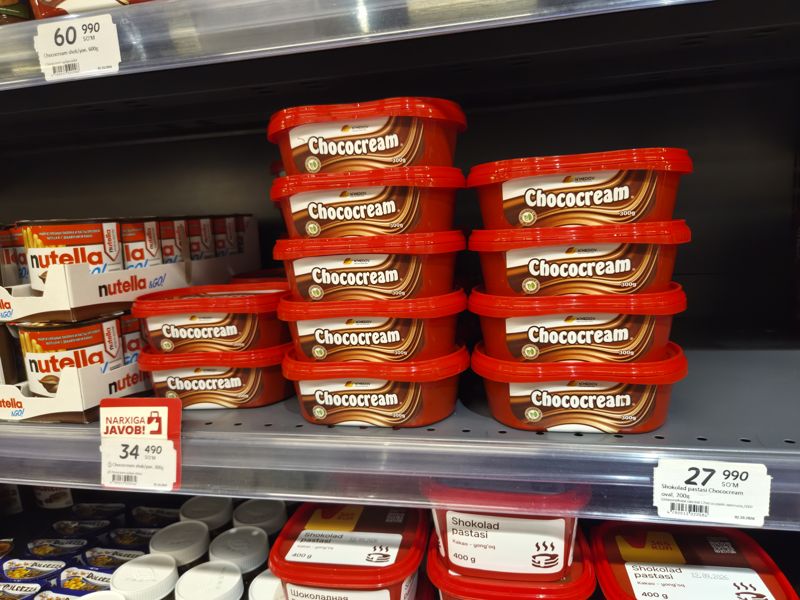 Шоколадная паста Chococream N'Medov в контейнерах на полке: 300 г с красной плашкой «Narxiga javob!», 200 г овальная, 600 г на верхней полке
