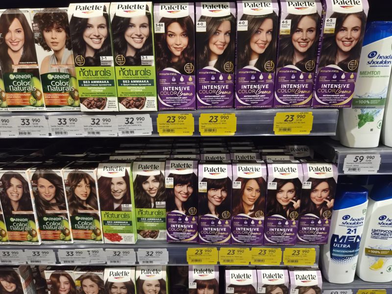 Краска для волос Garnier Color Naturals и Palette на двух полках с белыми и жёлтыми ценниками, справа шампуни Head & Shoulders