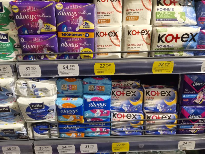 Женские прокладки Always, Kotex, Bella и Libresse на трёх полках с белыми и жёлтыми ценниками