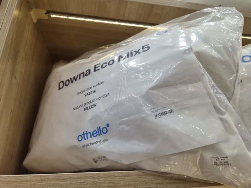 Подушка Othello Downa Eco Mix5 в упаковке в выдвижном ящике, справа внизу ценник магазина