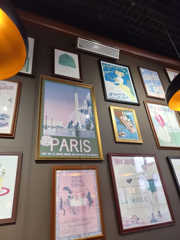 Интерьер кафе Bon!: стена с постерами в рамках (Paris, Amandines de Provence, Coffee, Tea-Time Tango, La Boxe)