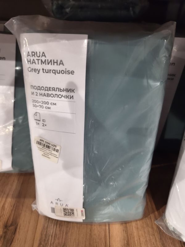 Комплект постельного белья ARUA Натмина серо-бирюзового цвета в прозрачной упаковке на полке: пододеяльник и 2 наволочки 200×200 / 50×70 см, на упаковке наклейка с ценой и QR