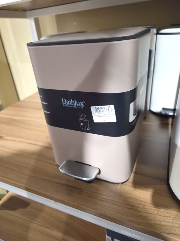 Мусорное ведро с педалью бежевого цвета Bathlux 5 л на деревянной полке с биркой Scandi Home, рядом белые вёдра