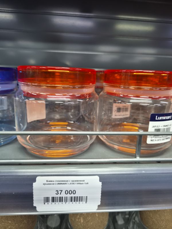 Стеклянные банки Luminarc JAR 0,5 л с оранжевыми крышками на полке, ценник на банку L8342 (37 000)
