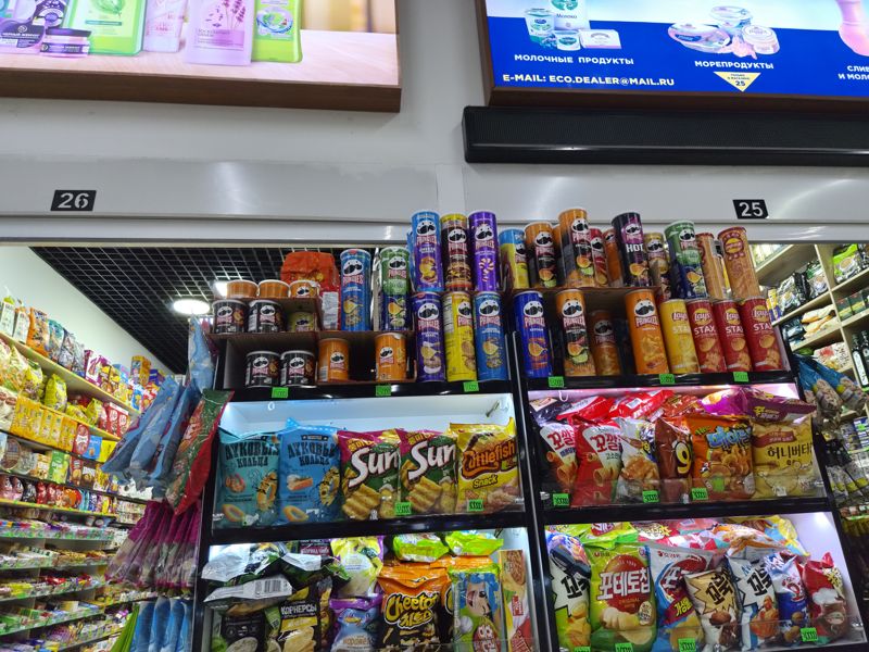 Магазин №25–26 Экобазара: полки с чипсами Pringles и Lay's Stax, луковыми кольцами, корейскими снеками