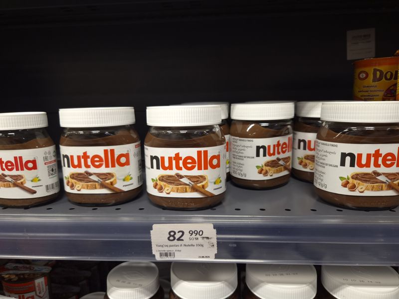 Шоколадная паста Nutella в стеклянных банках на полке с ценником