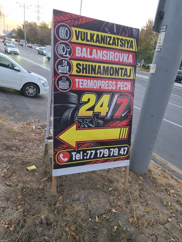 Roadside signboard: vulcanization, wheel balancing, tire fitting, thermal press, “24/7”, an arrow…